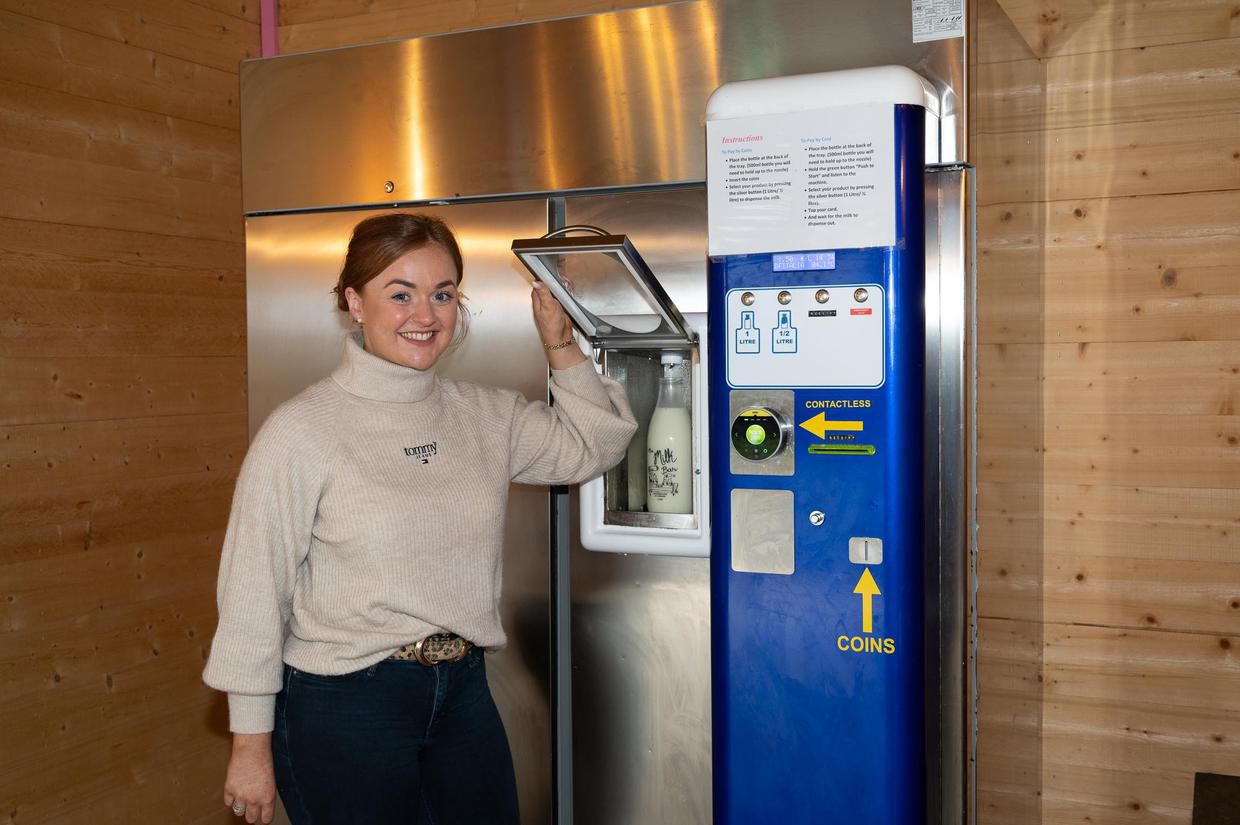 Megan beside the self-serve milk vending machine in the farm shop